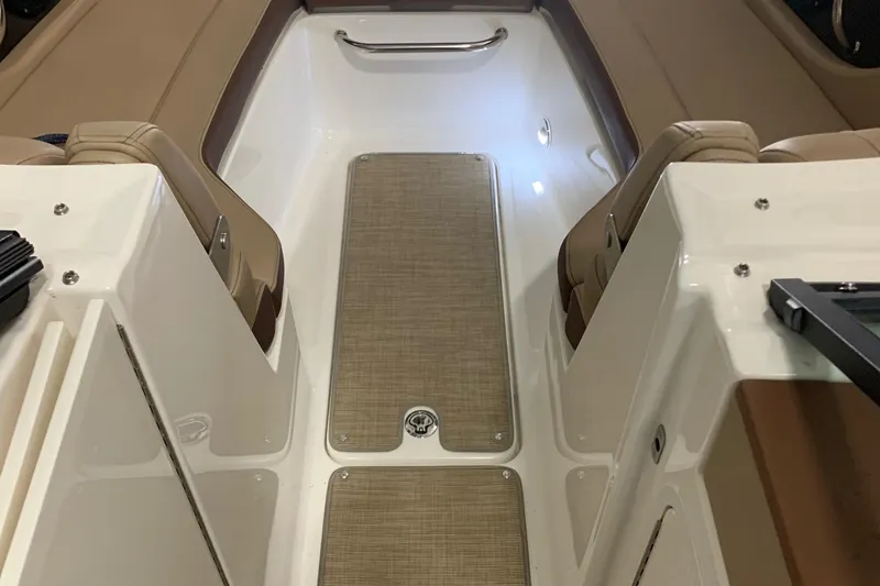 Slide: The Image of Interior of a Sea Ray 240 Sundeck boat with beige seats and carpeted flooring. - 23