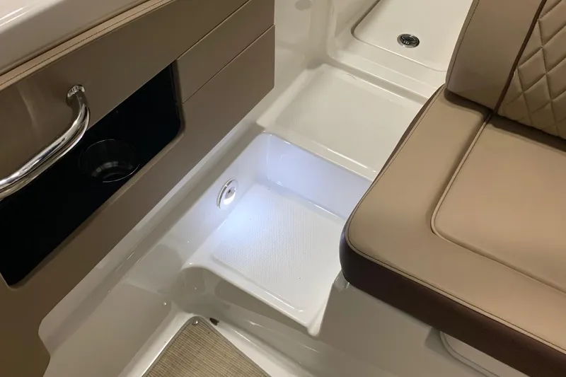 Slide: The Image of Interior of a Sea Ray 240 Sundeck with beige seating and storage compartment. - 24
