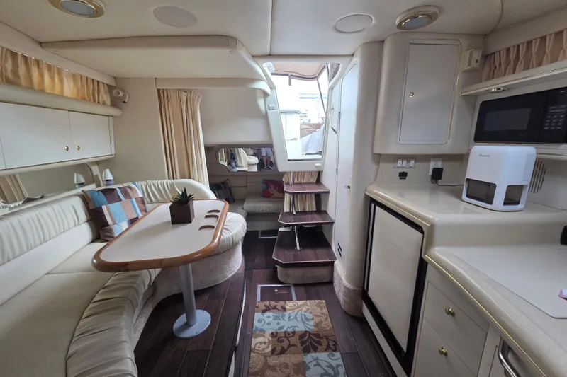Slide: The Image of Interior of 1999 Sea Ray 340 Sundancer yacht with cozy seating and kitchenette. - 13