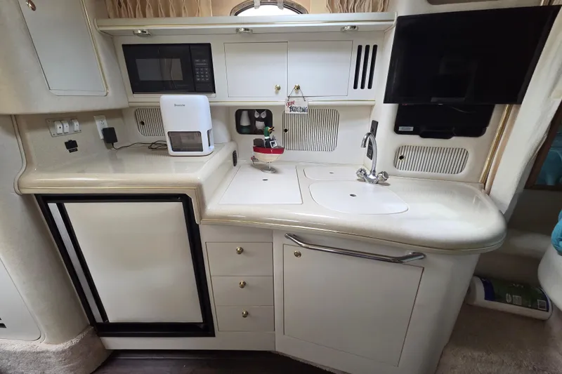 Slide: The Image of Compact kitchen area in a 1999 Sea Ray 340 Sundancer yacht with modern amenities. - 16