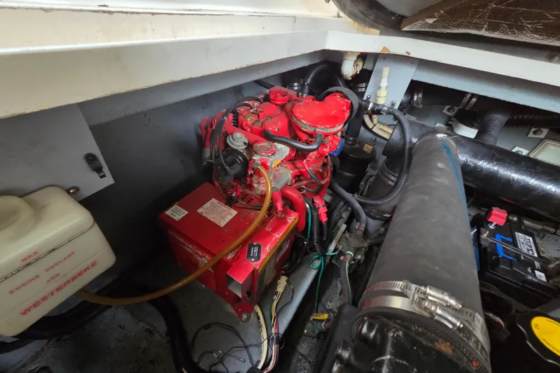 Slide: The Image of Engine compartment of a 1999 Sea Ray 340 Sundancer boat, featuring a red engine. - 24