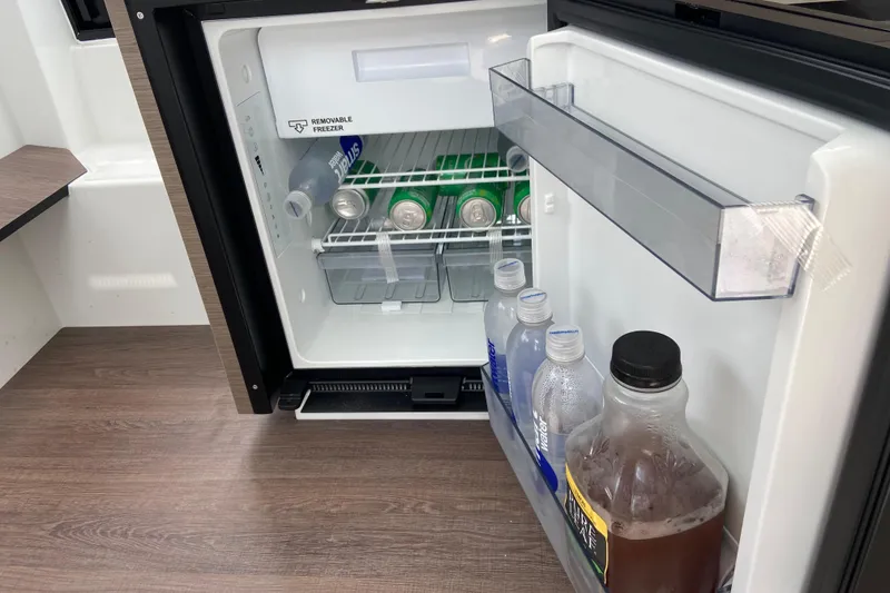Slide: The Image of Mini fridge stocked with drinks inside Jeanneau NC 895 Series 2 boat, 2026 model. - 36