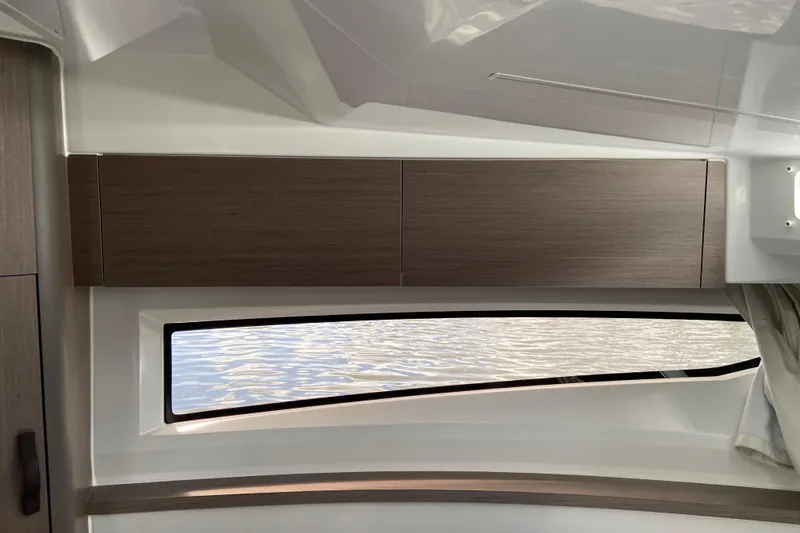 Slide: The Image of Interior view of 2026 Jeanneau NC 895 Series 2 boat, featuring sleek wood cabinetry and window. - 44