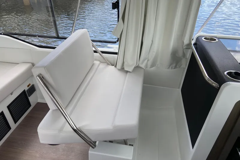 Slide: The Image of Interior seating of 2026 Jeanneau NC 895 Series 2 boat, featuring white cushions and metal railings. - 17