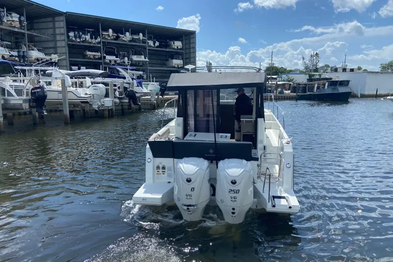 Slide: The Image of 2026 Jeanneau NC 895 Series 2 boat with dual engines in a marina setting. - 5