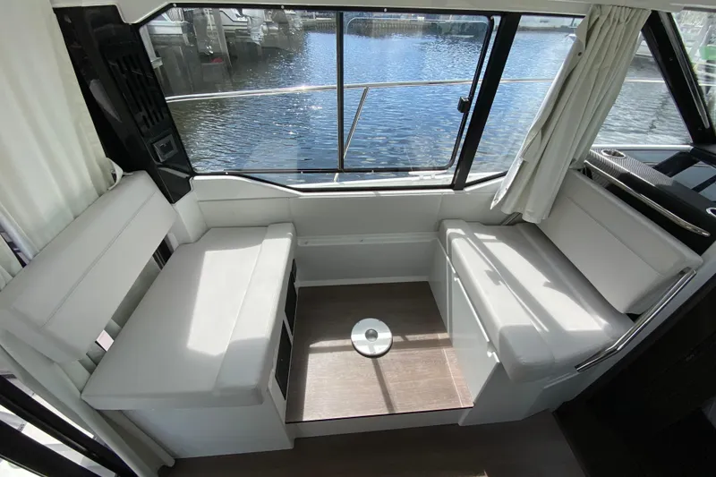 Slide: The Image of Interior of 2026 Jeanneau NC 895 Series 2 boat with white seating and waterfront view. - 16