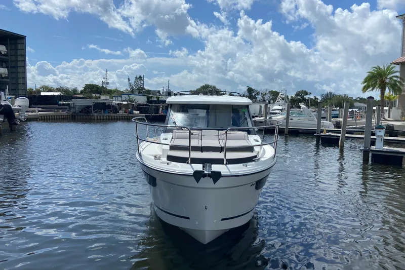 Slide: The Image of 2026 Jeanneau NC 895 Series 2 boat docked in a marina under a partly cloudy sky. - 1