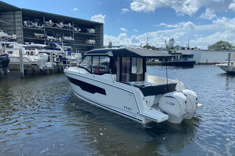 Slide: The Image of 2026 Jeanneau NC 895 Series 2 boat docked, featuring twin Yamaha engines, under a partly cloudy sky. - 4