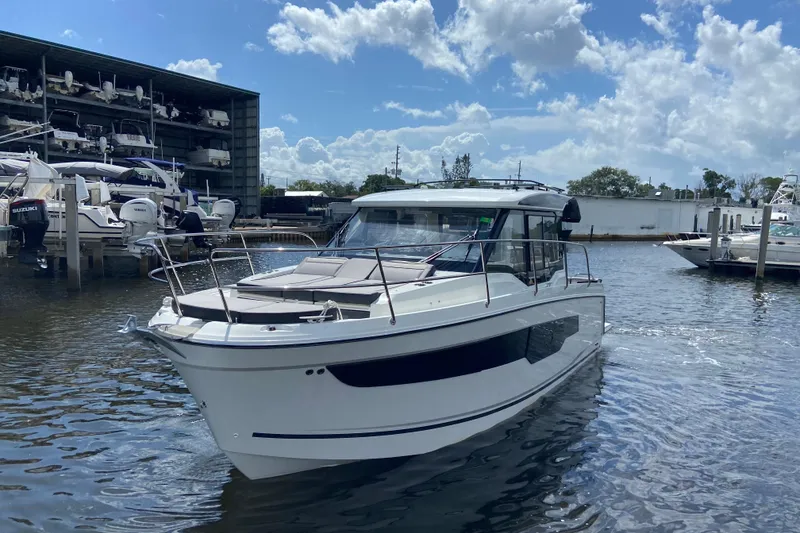 Slide: The Image of 2026 Jeanneau NC 895 Series 2 boat docked at marina under a partly cloudy sky. - 2
