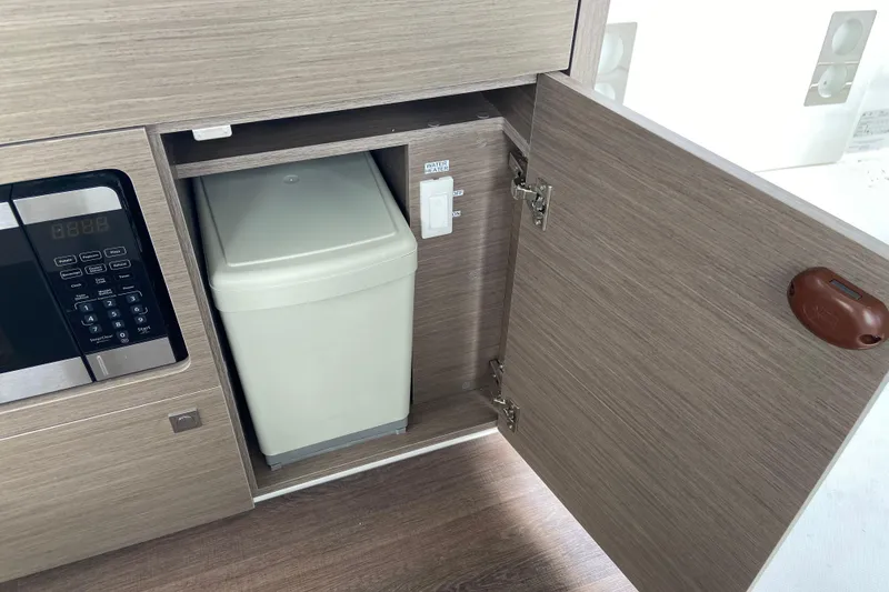 Slide: The Image of Interior of 2026 Jeanneau NC 895 Series 2 showing a cabinet with a trash bin. - 32