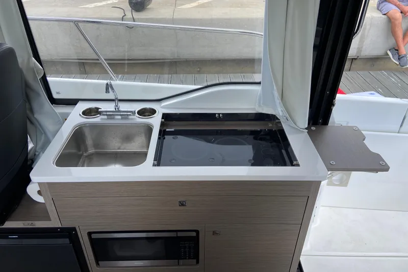 Slide: The Image of Compact kitchen area on 2026 Jeanneau NC 895 Series 2 boat, featuring sink and stove. - 29