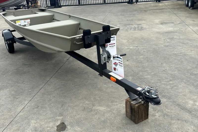 Slide: The Image of 2026 Tracker Grizzly 14 Jon boat on trailer, displayed outdoors on concrete surface. - 2
