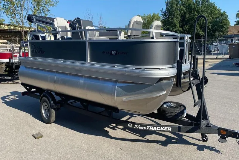 Slide: The Image of 2026 Sun Tracker Bass Buggy 18 DLX pontoon boat on trailer in outdoor setting. - 3