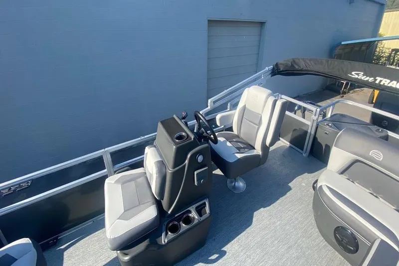 Slide: The Image of 2026 Sun Tracker Bass Buggy 18 DLX pontoon boat interior with steering console and seating. - 7