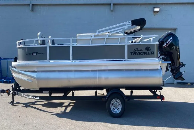 Slide: The Image of 2026 Sun Tracker Bass Buggy 18 DLX pontoon boat on trailer, parked outdoors. - 86