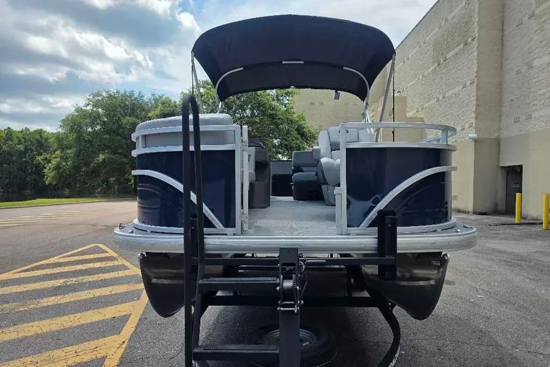 Slide: The Image of 2026 Sun Tracker SportFish 20 DLX pontoon boat on trailer, parked outdoors. - 6