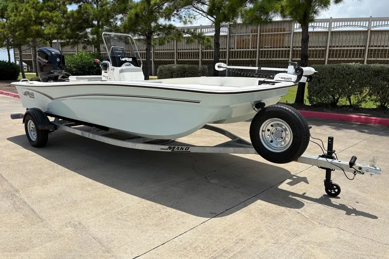 Slide: The Image of 2026 Mako Pro Skiff 17 CC boat on trailer, parked outdoors. - 2
