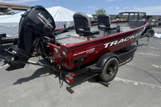 Slide: The Image of 2026 Tracker Super Guide V-16 T boat with Mercury engine, parked outdoors. - 2