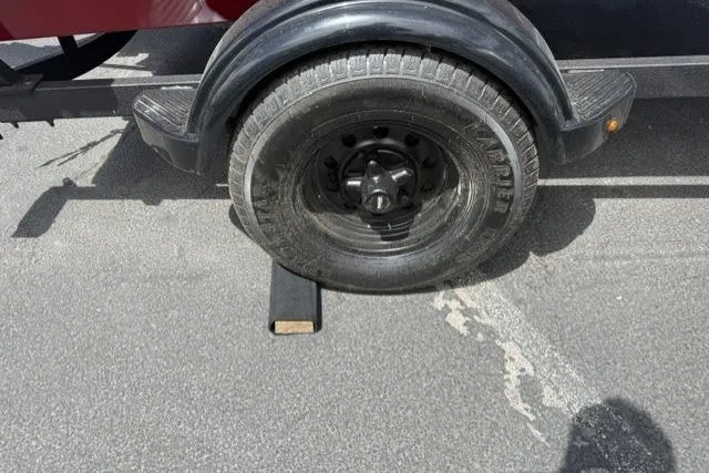 Slide: The Image of Trailer wheel of 2026 Tracker Super Guide V-16 T on asphalt with chock. - 7