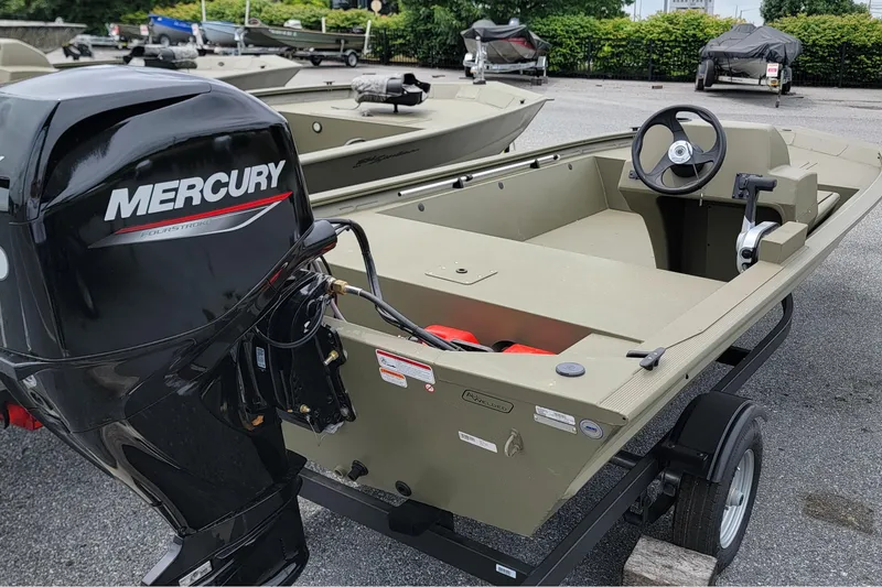 Slide: The Image of 2026 Tracker Grizzly 1648 SC boat with Mercury outboard motor on trailer. - 2