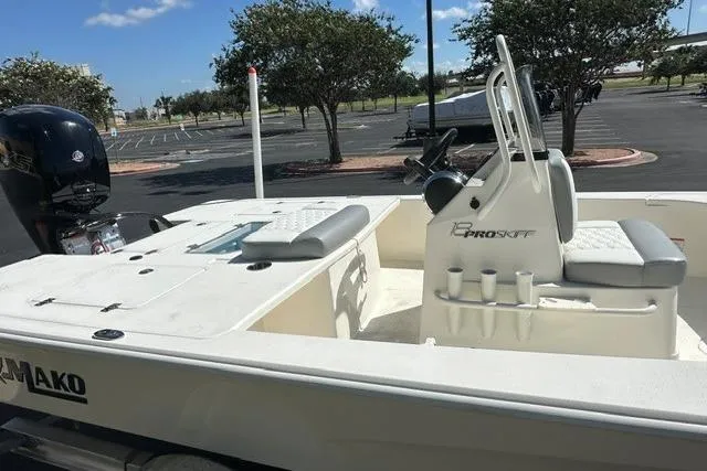 Slide: The Image of 2026 Mako 18 Pro Skiff boat with seating and console in a parking lot. - 3