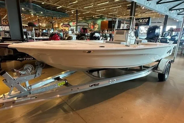 Slide: The Image of 2026 Mako 18 Pro Skiff boat displayed indoors on a trailer. - 6