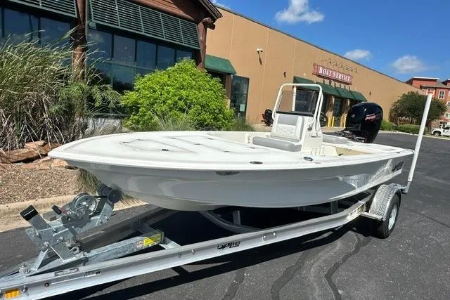 Slide: The Image of 2026 Mako 18 Pro Skiff on trailer, parked outside a boat service center. - 1