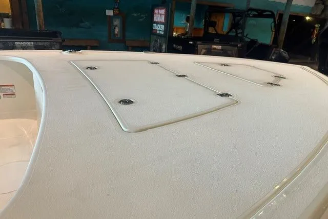 Slide: The Image of 2026 Mako 18 Pro Skiff boat deck with storage compartments in showroom. - 10