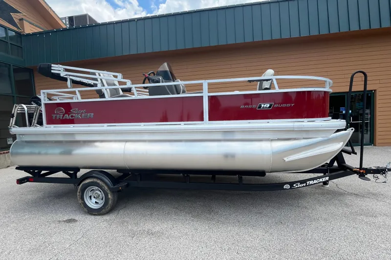 The Image of 2026 Sun Tracker Bass Buggy 18 DLX pontoon boat on trailer, parked outdoors. - 0