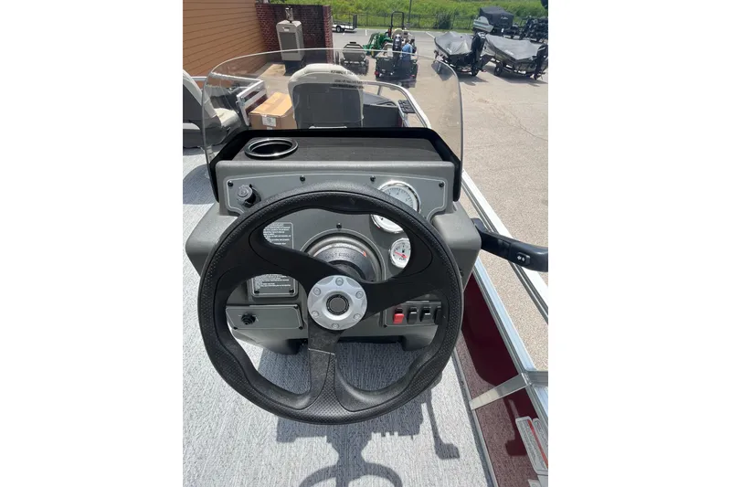Slide: The Image of 2026 Sun Tracker Bass Buggy 18 DLX steering console with gauges and controls. - 4