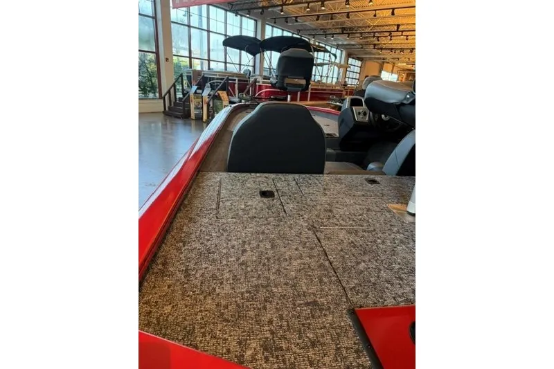 Slide: The Image of 2026 Tracker Pro Team 190 boat interior with carpeted deck and seating in showroom. - 6