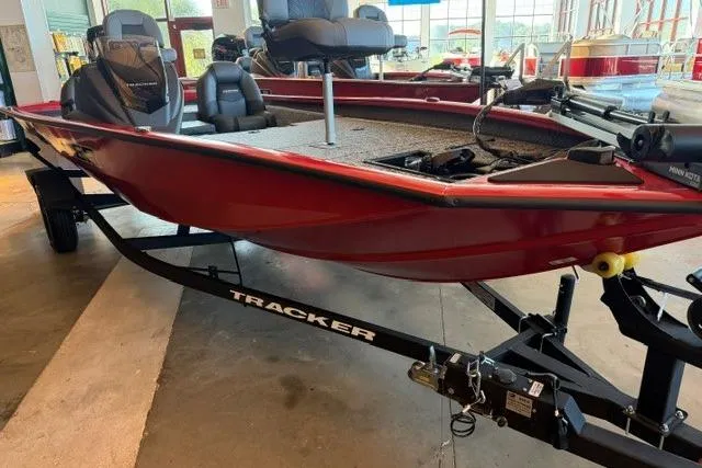 Slide: The Image of 2026 Tracker Pro Team 190 boat in showroom, red hull, on trailer. - 2
