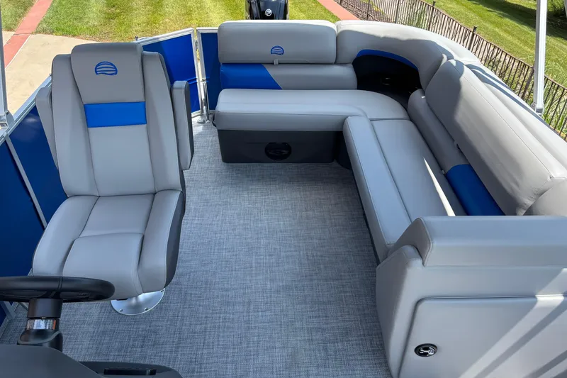Slide: The Image of 2026 Sun Tracker Party Barge 20 DLX interior with gray and blue seating, spacious layout. - 2
