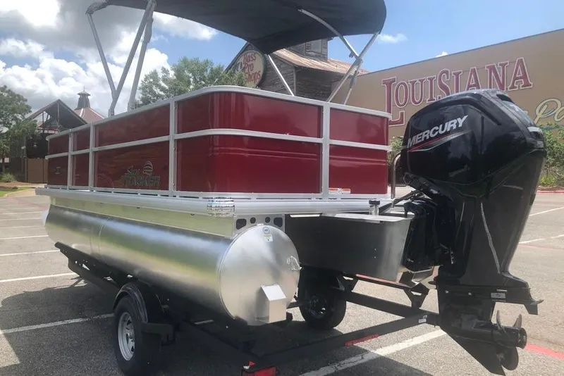 Slide: The Image of 2026 Sun Tracker Party Barge 18 DLX pontoon boat with Mercury engine in parking lot. - 2