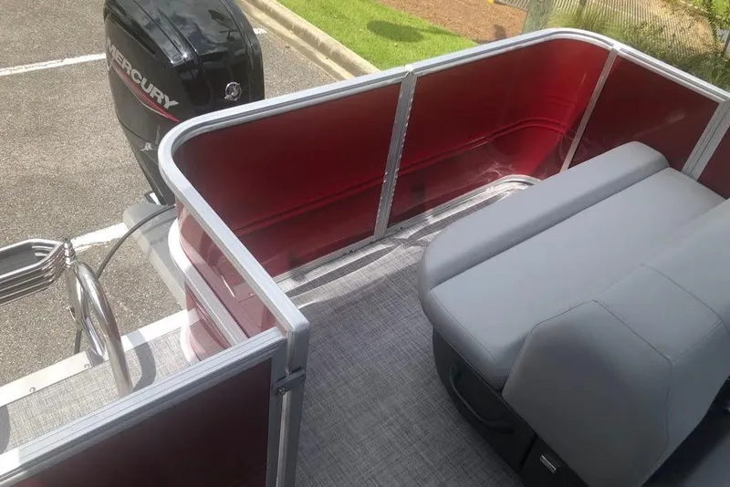 Slide: The Image of 2026 Sun Tracker Party Barge 18 DLX interior with red railing and gray seating. - 8