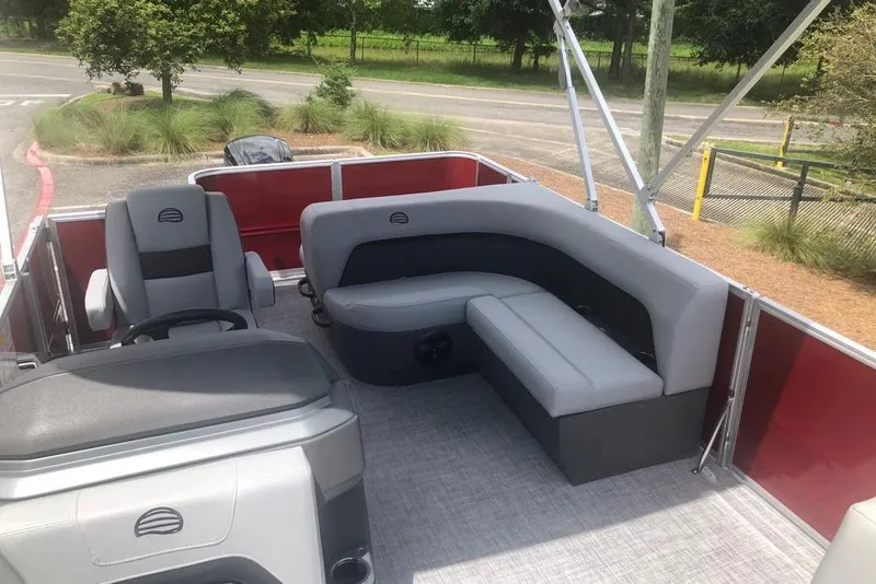 Slide: The Image of 2026 Sun Tracker Party Barge 18 DLX interior with gray seating and red accents. - 6