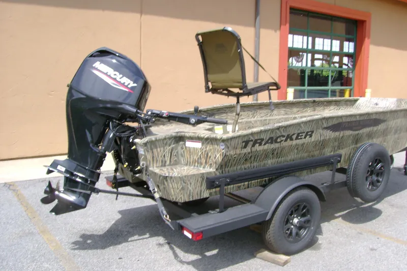 Slide: The Image of 2026 Tracker Grizzly 1650 T Prairie Wings Edition boat on trailer, featuring Mercury outboard motor. - 2