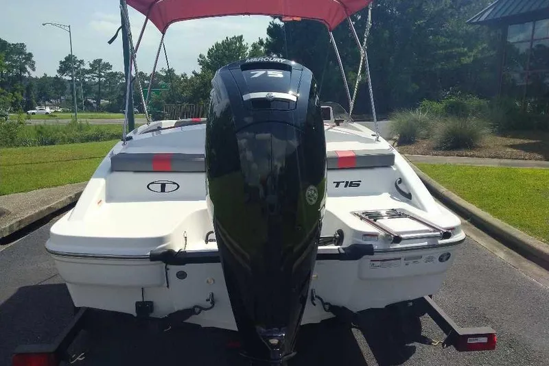 Slide: The Image of 2026 Tahoe T16 boat with Mercury 75 engine, parked outdoors under a red canopy. - 3