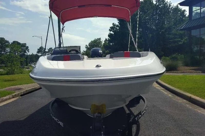 Slide: The Image of 2026 Tahoe T16 boat with red canopy, parked on a sunny day. - 8