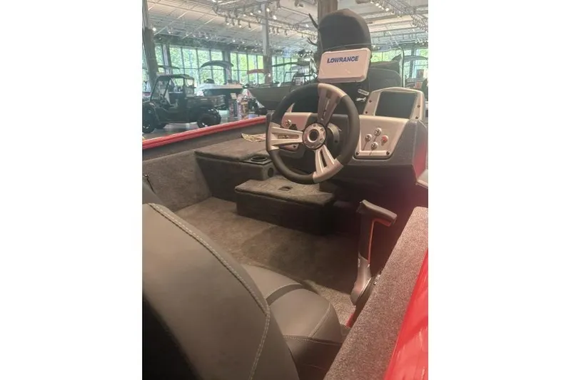 Slide: The Image of Interior of 2026 Tracker Pro Team 190 boat with steering wheel and control panel. - 2