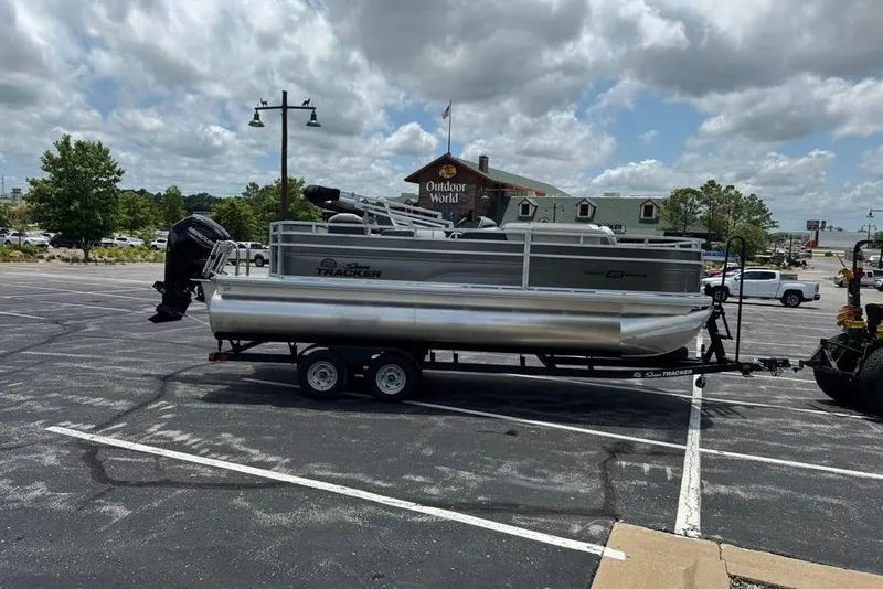 Slide: The Image of 2026 Sun Tracker Fishin' Barge 20 DLX pontoon boat on trailer in parking lot. - 10