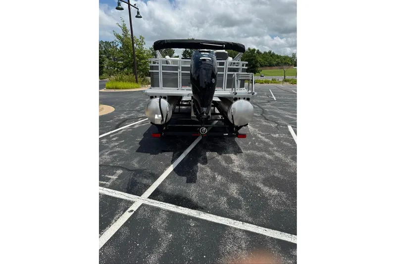 Slide: The Image of 2026 Sun Tracker Fishin' Barge 20 DLX pontoon boat in parking lot, rear view. - 13