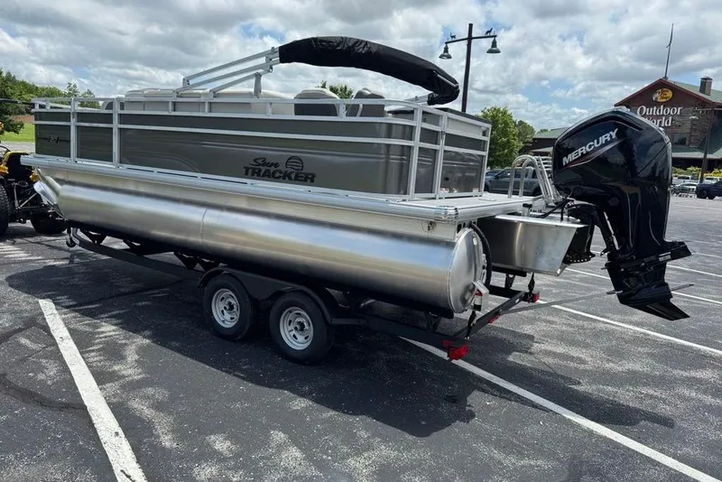 Slide: The Image of 2026 Sun Tracker Fishin' Barge 20 DLX pontoon boat on trailer in parking lot. - 4