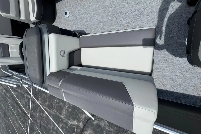 Slide: The Image of 2026 Sun Tracker Fishin' Barge 20 DLX interior seating with gray and white upholstery. - 6