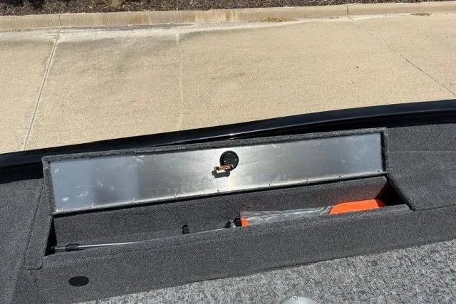 Slide: The Image of 2026 Tracker Super Guide V-16 SC boat storage compartment with lock and carpeted interior. - 53