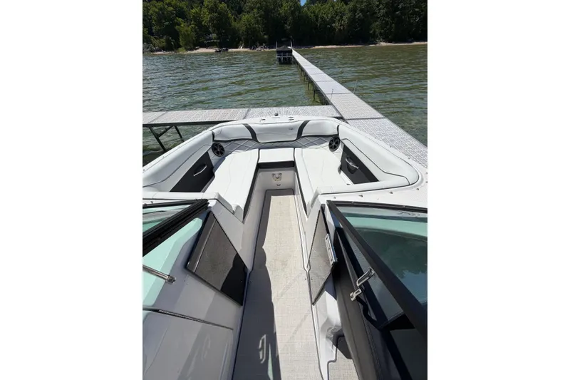 Slide: The Image of 2022 Regal 22 FasDeck boat interior with seating, docked by a scenic lake. - 4