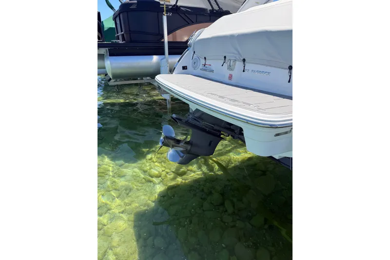 Slide: The Image of 2022 Regal 22 FasDeck boat stern in clear water, showcasing propeller and swim platform. - 15