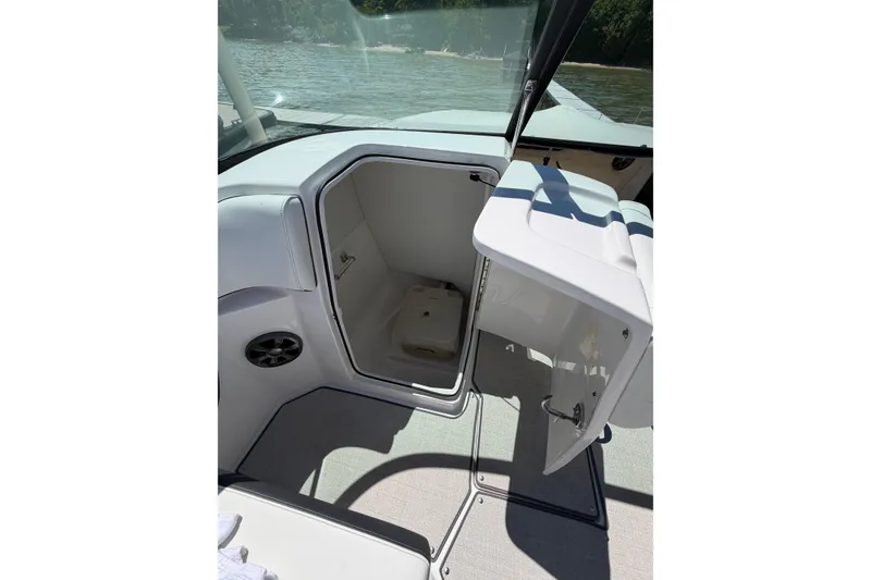 Slide: The Image of 2022 Regal 22 FasDeck boat interior with open storage compartment by the water. - 16