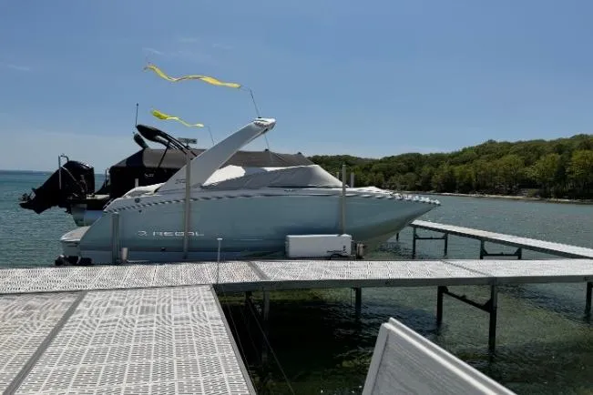 Slide: The Image of 2022 Regal 22 FasDeck boat docked on a sunny lake with trees in the background. - 8
