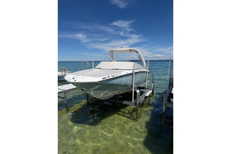 The Image of 2022 Regal 22 FasDeck boat on lift, clear water, sunny day, blue sky. - 3